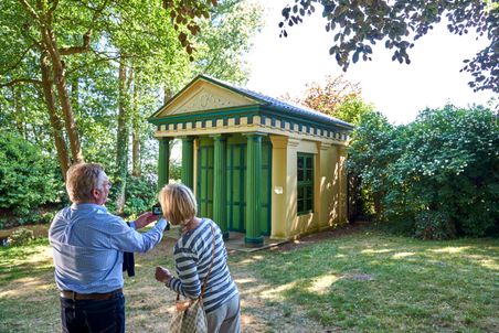 Ehepaar fotografiert auf dem Rundgang durch das Klostergelände in Uetersen das gelbe Teehaus. Kreis Pinneberg