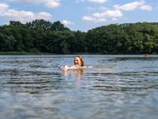 Frau schwimmt in einem See in Holstein.