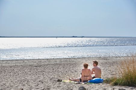 Ein Paar liegt am Elbstrand in Kollmar und genießt die Aussicht auf die Elbe. Kreis Steinburg