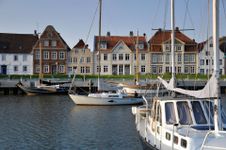 Blick über den Glückstädter Hafen, auf dem Segelschiffe liegen, auf die hübsche historische Häuserzeile.