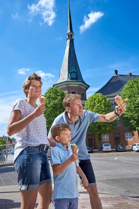 Familie isst ein Eis vor der Kirche in Wilster