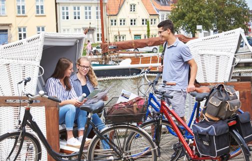 Eine Gruppen von Freunden macht am Hafen in Glückstadt Pause und hat es sich in Strandkörben gemütlich gemacht.