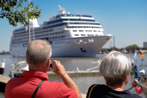 Paar fotografiert ein Kreuzfahrtschiff in Brunsbüttel