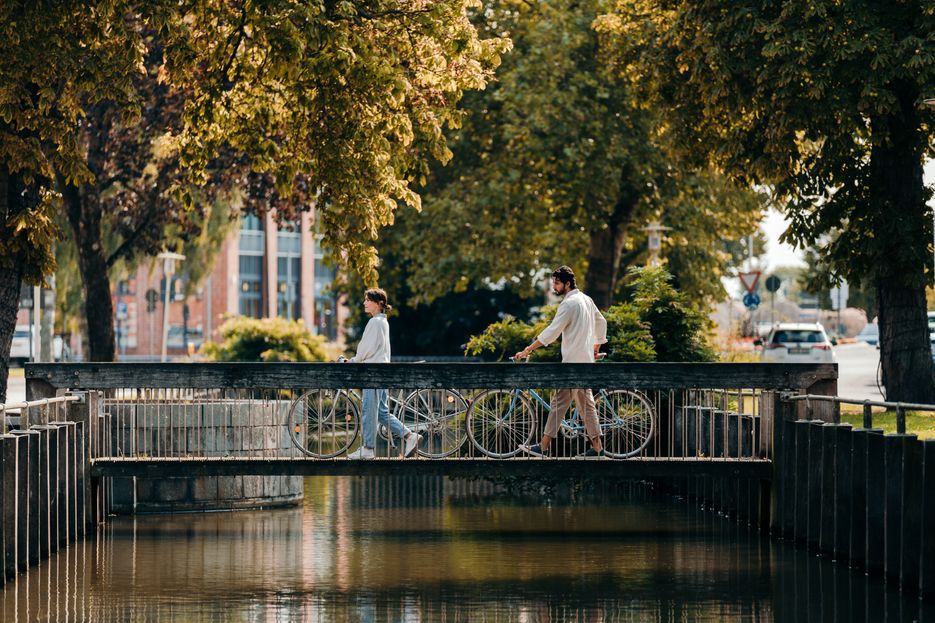 Paar schiebt Fahrräder über eine Brücke