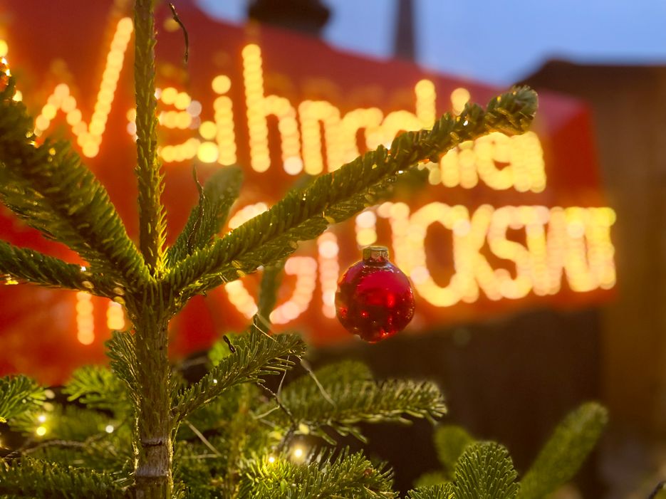 Weihnachtsbaum vor einem Schild mit Weihnachtsmarkt Glückstadt