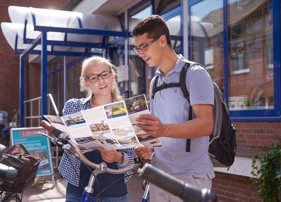 Ein Paar hat sich in der Tourist-Information eine Karte geholt und plant nun eine Radtour.