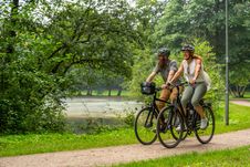 Paar genießt eine Fahrradtour im Grünen und fährt durch den Kurpark in Bad Bramstedt.